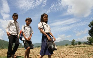 Srey Yeng, 8-year old girl, walking to school with her brothers.