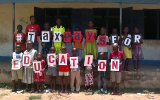 Pupils at the Activista Free Holiday Coaching Lesson in Tionsha community in Benue State Nigeria taking action as part of the Tax Power Campaign 