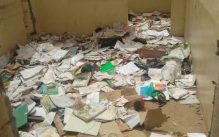 Textbooks and class materials on the floor of former school site