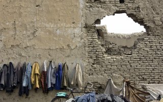 Afghan students' coats hanged on the wall destroyed by the war, Kabul, Afghanistan 