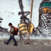 Palestinian boy passing by a grafitti as he walks to school at Jabalia area, northern Gaza Strip