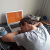 Student sleeping on laptop at desk
